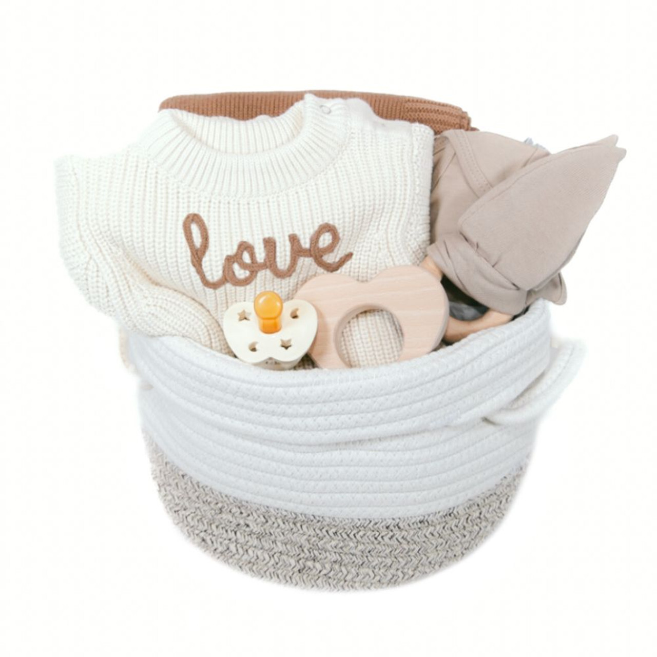 Baby gift basket from Our Green House, containing a white sweater with ‘love’ written on it.