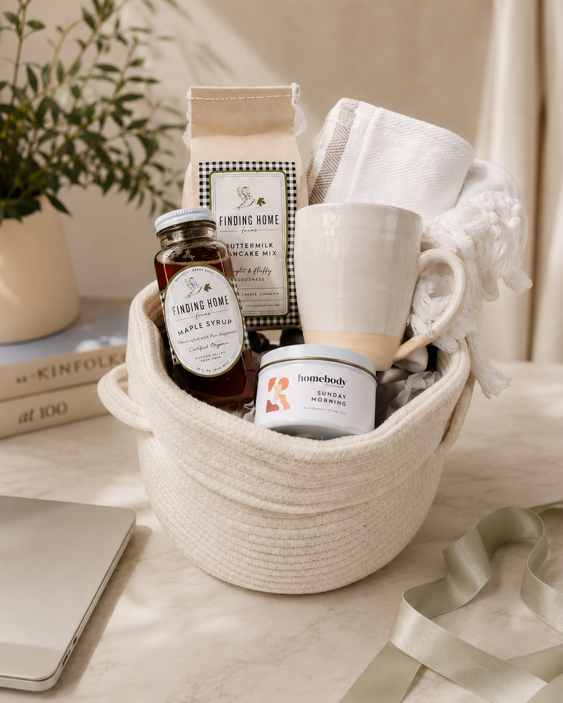 Our Green House breakfast gift basket with pancake mix, maple syrup, a ceramic mug, a candle, and a kitchen towel.