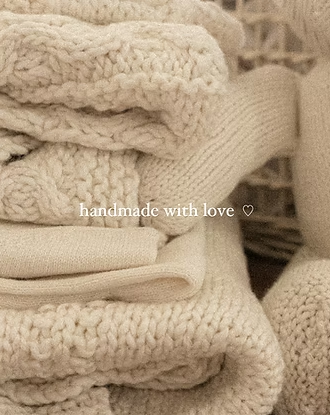 Stack of cream handknit blankets with “handmade with love” text from Our Green House.