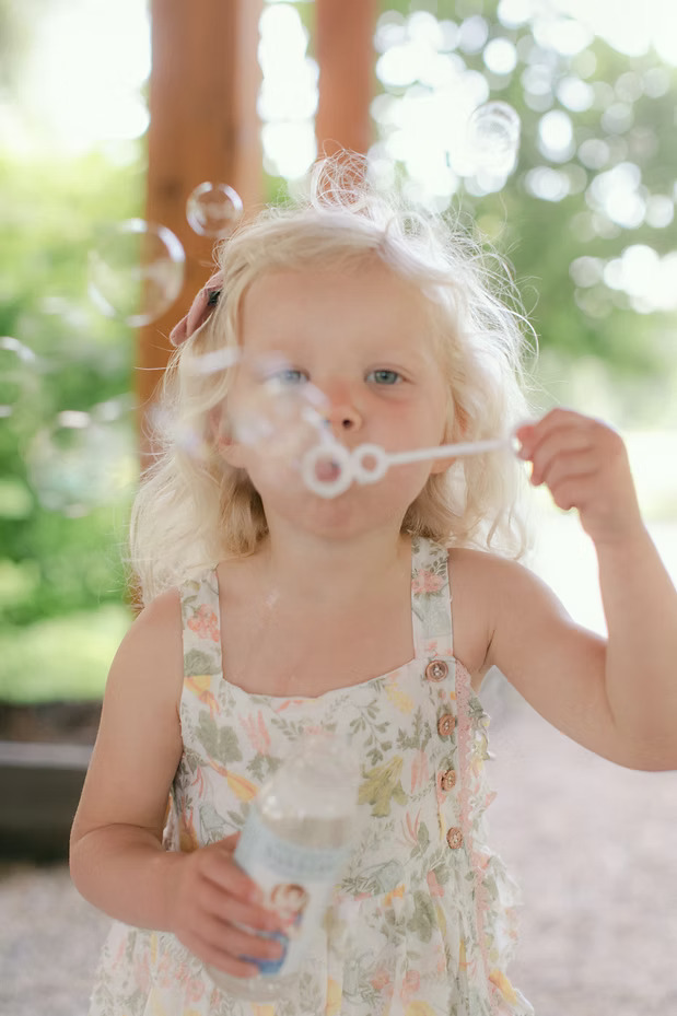 girl-blowing-bubbles Girl blowing bubbles outdoors.