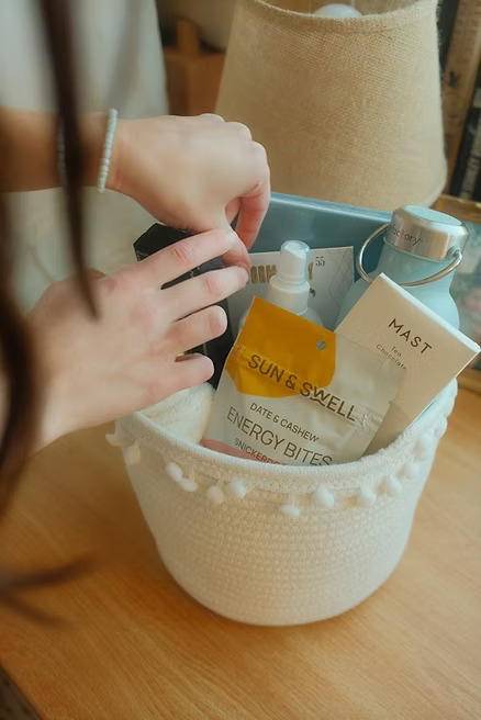 hands-arranging-gift-basket.jpg Hands placing items in gift basket