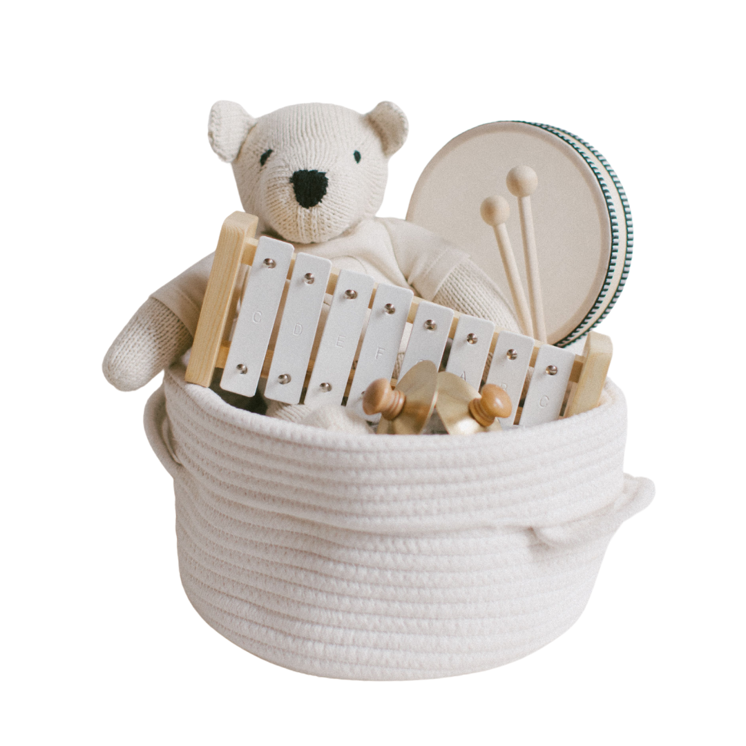 Our Green House Teddy’s Tunes musical gift basket with plush teddy, wooden xylophone, and hand drum in a rope bin.