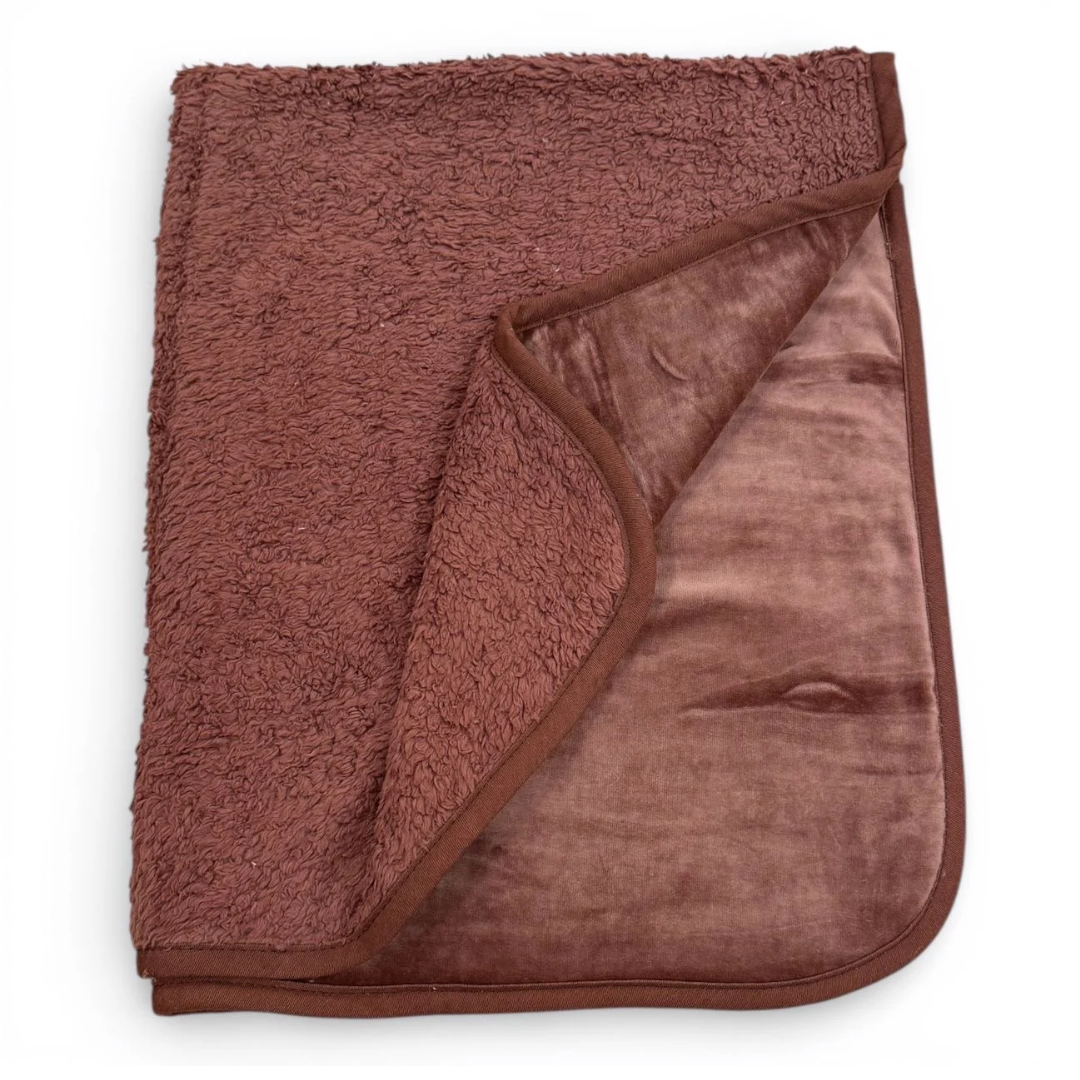 Brown organic dog blanket folded on a clean surface, showing soft, natural fabric.