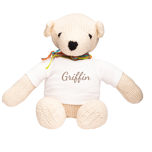 An organic stuffed teddy bear wearing a personalized baby name t-shirt from Our Green House.