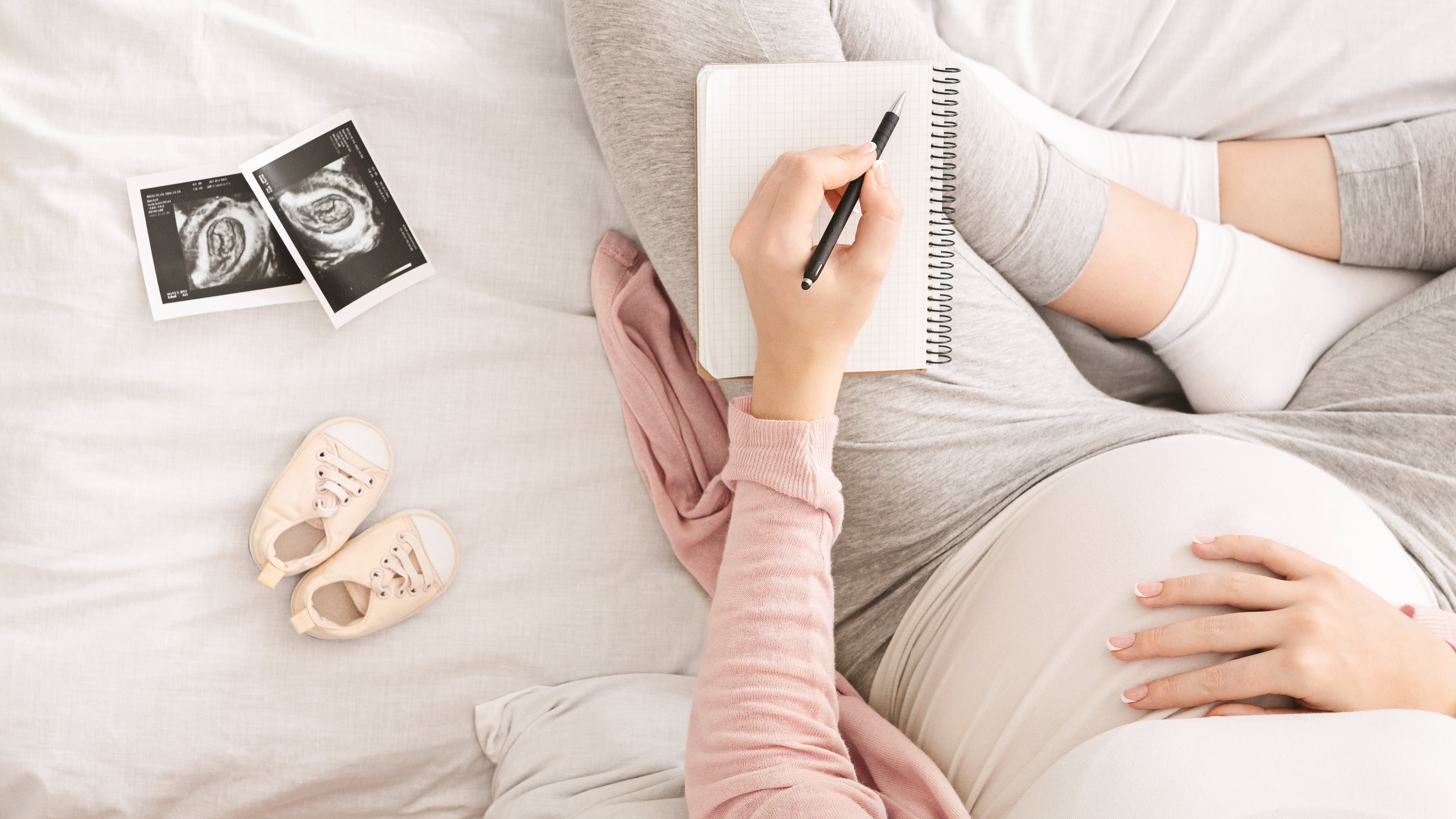 A pregnant woman writing in a jounal